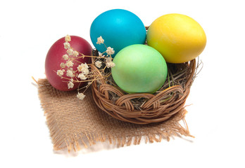 Easter eggs in a wicker basket isolated on a white background