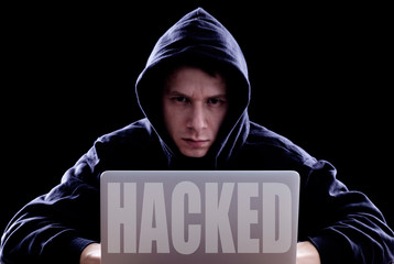 Hacker using laptop for organizing attack on corporate servers