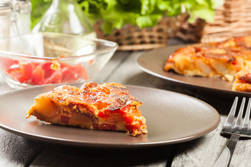 Tortilla de patatas. Spanish omelette with sausage chorizo, potatoes, paprika and egg, accompanied by olive oil