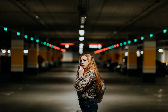Pretty woman smoking on parking