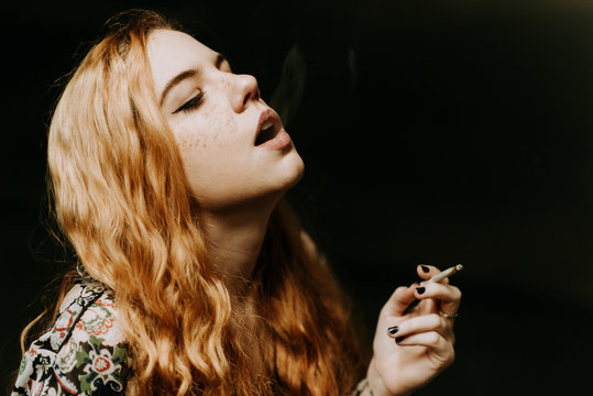 Pretty woman smoking on parking
