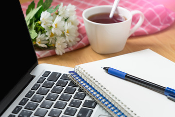 Office working with laptop, notebook and coffee cup.