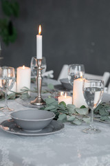 Wedding or festive table setting. Plates, wine glasses, candles and cutlery
