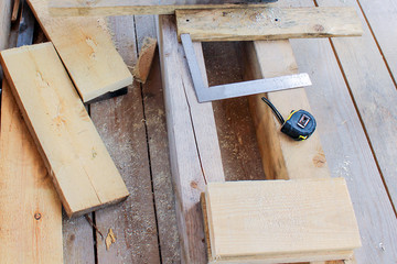 Construction of a wooden frame house - tape measure, gon, tools, cutting and measuring of boards.