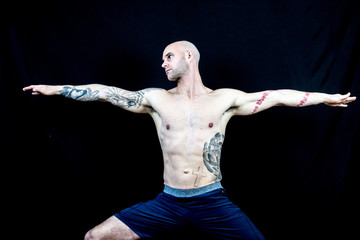 Fototapeta na wymiar Muscular man performs Yoga and meditation