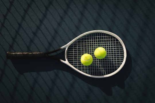 Tennis ball and racket in tennis court