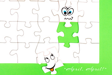 Puzzle pieces with tow funny faces and the words april, april