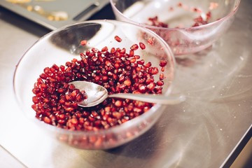Red pomegranate seeds in glass bowl