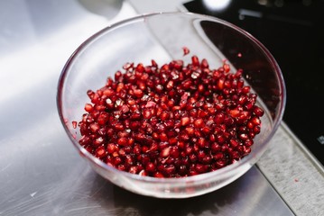 Red pomegranate seeds in glass bowl