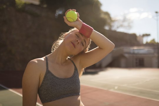 Woman sweating while playing tennis in the tennis court