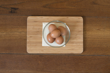 some eggs in a glass bowl on a wooden table