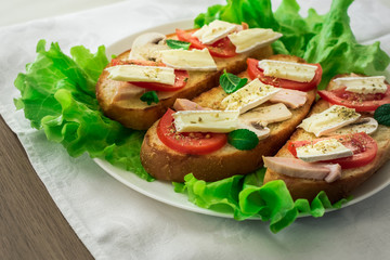Italian bruschetta with chicken, tomatoes, mushrooms, cheese brie
