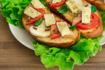 Italian bruschetta with chicken, tomatoes, mushrooms, cheese brie