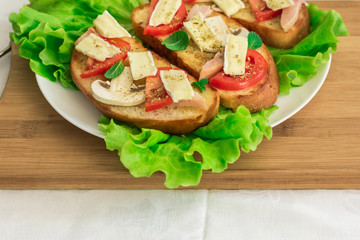 Italian bruschetta with chicken, tomatoes, mushrooms, cheese brie