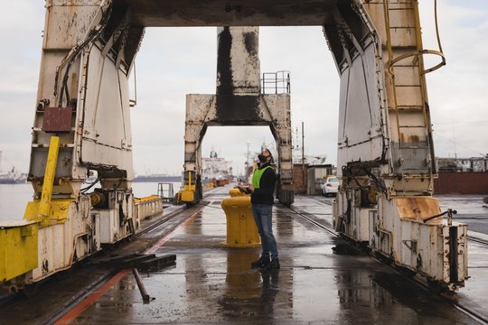 Dock worker inspecting the huge cranes