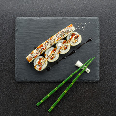 Sushi rolls, maki, nigiri Set served for two on black stone slate on dark background copy space