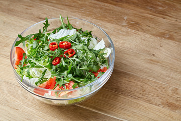 Dietary mixed salad in glass sultana on rustic wooden background, selective focus
