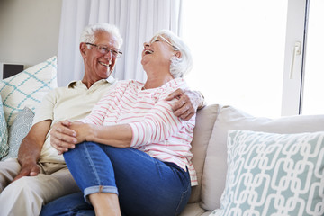 Senior Couple Relaxing On Sofa At Home Together