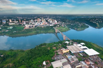 Fototapete Südamerika Luftaufnahme der paraguayischen Stadt Ciudad del Este und der Freundschaftsbrücke, die Paraguay und Brasilien durch die Grenze über den Parana-Fluss verbindet.