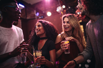 Happy friends enjoying nightout at bar - obrazy, fototapety, plakaty