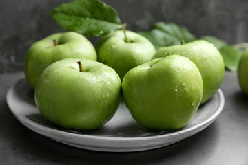 Plate with fresh green apples on table, closeup