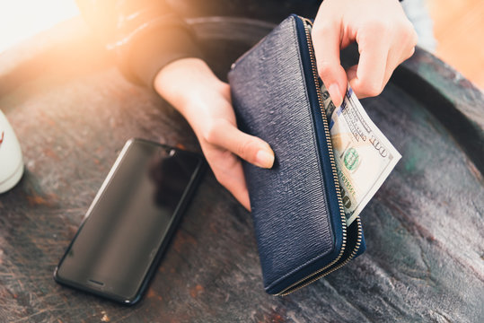 the businesswoman take out the banknote from the wallet on the wooden table. the concept of payment, financial, business, trading and investment.