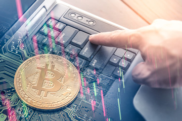 The double exposure image of the business man using a laptop computer overlay with bitcoin and stock graph image. the concept of cryptocurrency, blockchain, internet of things and future life