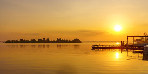 Sunset sun over the island of Voroniy on Lake Seliger