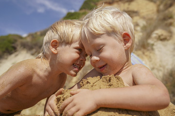  Two little boys three years old  play on a sandy beach, twins © Hanna