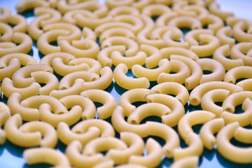 Dry pasta in the shape of a horn on a blue plate
