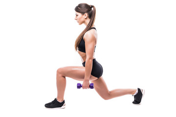 Beautiful young woman doing lunge exercise with red dumbbells in fitness gym isolated over white background