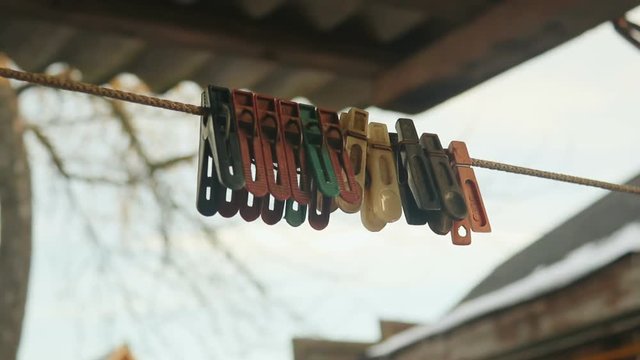 old colored clothespins on a clothesline against the evening sky