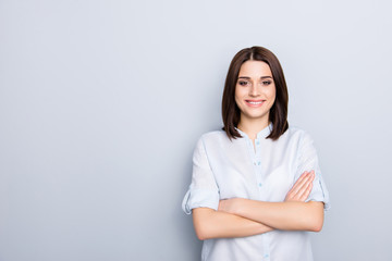 Portrait with copy space, empty place of caucasian, nice, cute, modern girl with short hair having her arms crossed, isolated on grey background, looking at camera