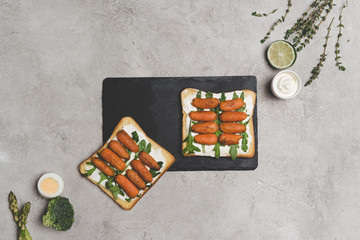 top view of healthy sandwiches with arugula and roasted baby carrots on slate board