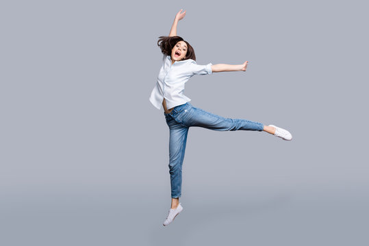 Full length, full size, fullbody portrait of pretty, charming, modern, stylish girl jumping in the air yelling with wide open mouth, celebrating successfully pass exams, isolated on grey background