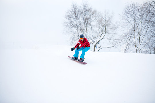 Image of snowboarder man jumping on snowy hill