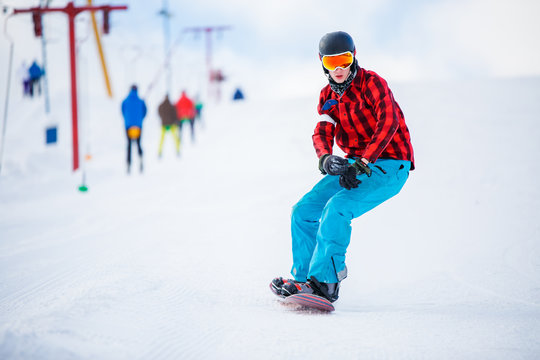 Photo of athlete with snowboard riding in snowy resort
