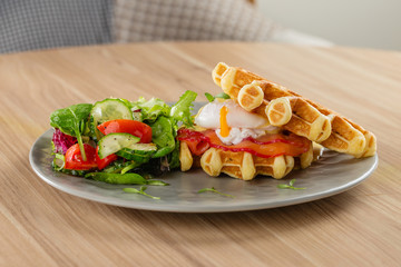 Savory Belgian waffles with egg poached, salmon and salad. eggs benedict - American breakfast