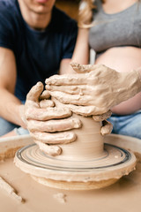Obraz na płótnie Canvas Family young couple make ceramic pot using pottery wheel close up