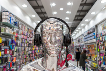 Obraz premium Silver glossy mannequin in modern headphones in the store.
