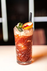 Red cocktail with mint on the white bar
