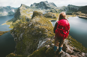 Traveler woman discovering  mountains of Norway with red backpack Traveling healthy lifestyle...