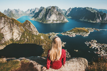 Tourist woman relaxing on cliff mountain admiring amazing landscape traveling in Norway healthy lifestyle concept adventure outdoor summer vacations Reinebringen aerial view Lofoten islands