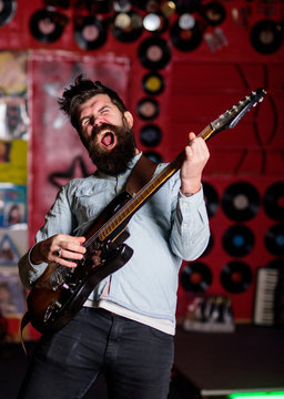 Rock singer concept. Musician with beard play electric guitar instrument.
