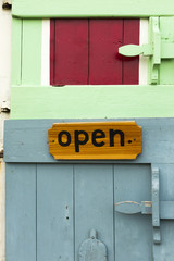 Colorful wooden door at local rural shop with tablet 'open'