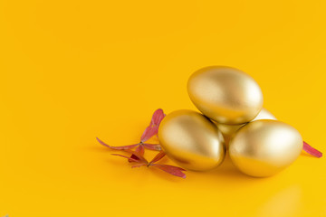 Golden egg on a yellow background. copy space