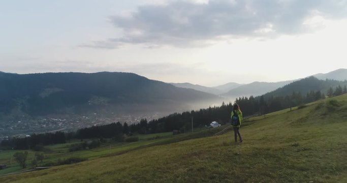 The girl admires the sunrise in the Carpathian mountains