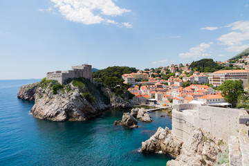 Fototapeta na wymiar Dubrovnik Stadt mit Rundweg, Hafen, Dächer und Kreuzfahrt Schiffe am Meer strahlend blauen Himmel