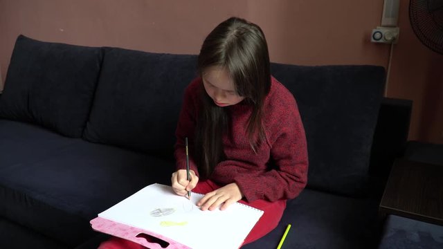 Down Syndrome Girl Is Drawing At Home 