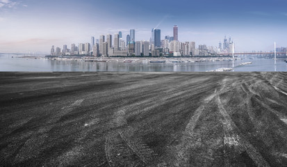 The empty asphalt road is along the modern commercial building in the Chinese city